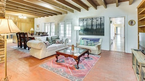 A spacious living room with a fireplace, a large painting, and a dining area with wooden furniture. - 3 Mi to Zoo & Garden: ABQ Home w/ Private Pool! (Albuquerque)