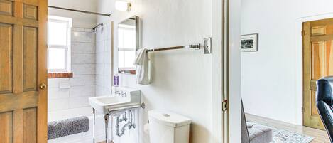 A bathroom with a toilet, sink, and shower area.