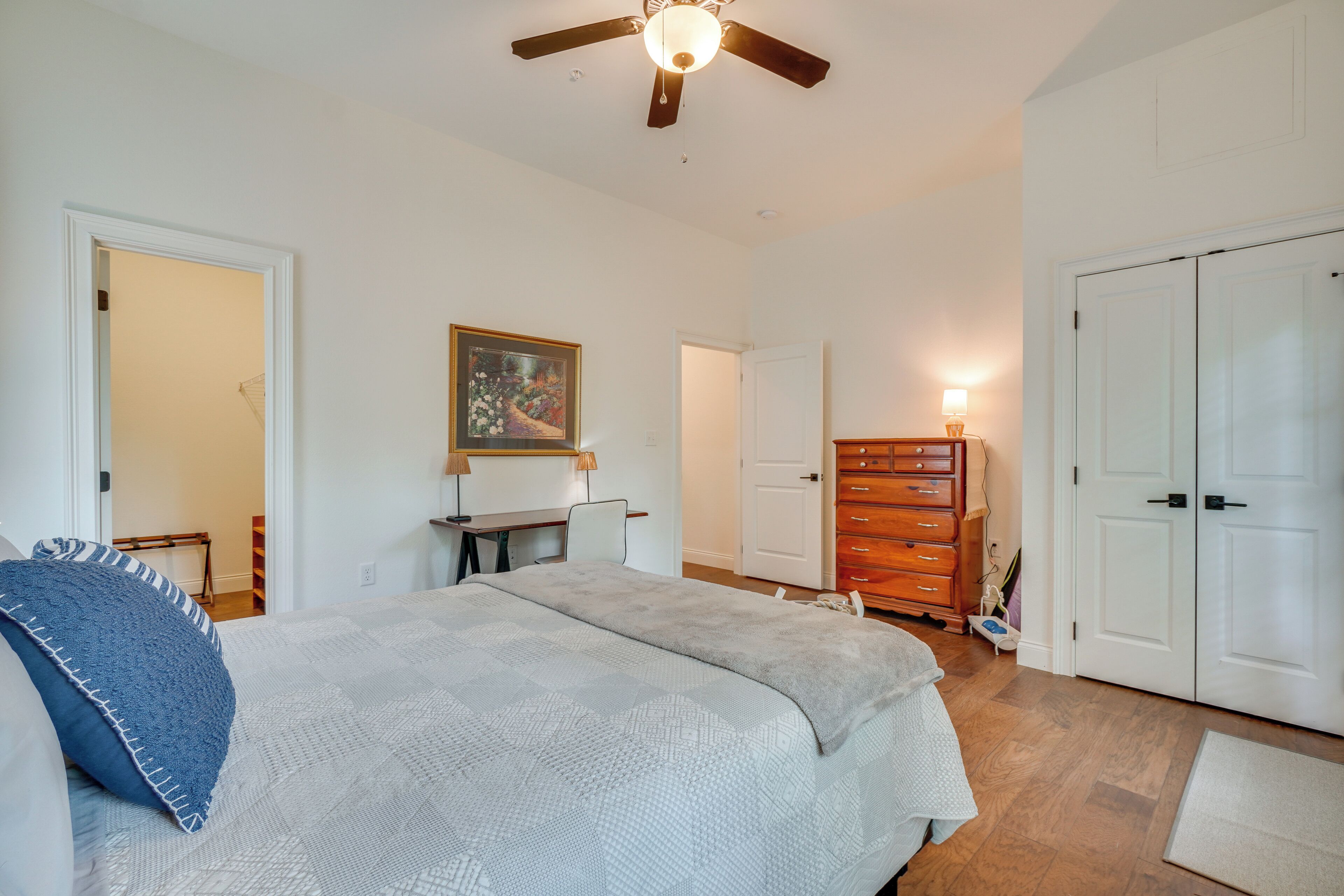 A bedroom with a bed, a desk, a dresser, and a wardrobe.