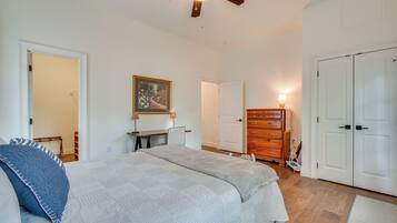 A bedroom with a bed, a desk, a dresser, and a wardrobe.