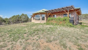 A house with a green roof, large windows, and a covered porch. - Hunt, Fish & Explore: Mtn-view Home in Hotchkiss (Hotchkiss)