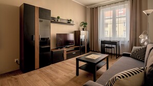 Un soggiorno moderno con un divano, un tavolino, una TV e un'area pranzo.