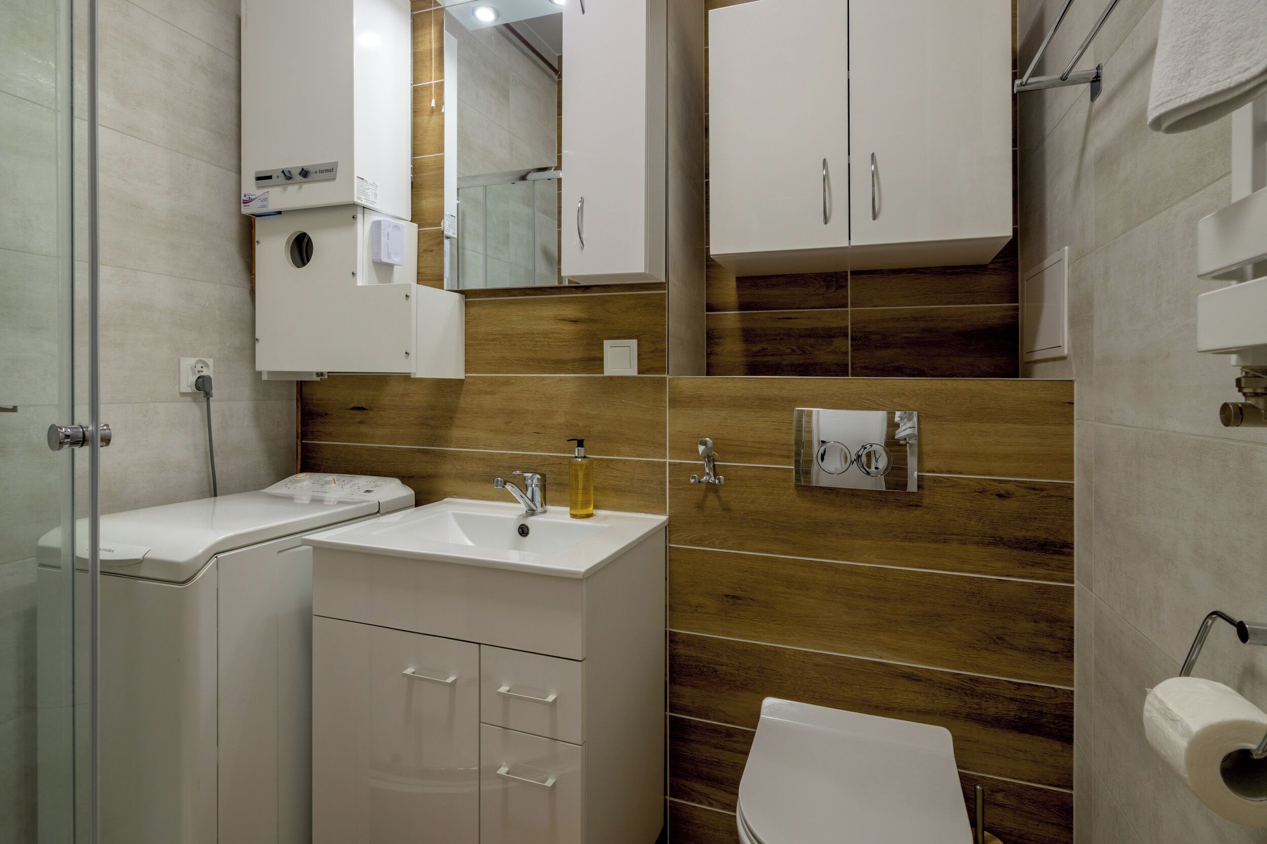 Une salle de bain moderne avec un lavabo blanc, un miroir et des toilettes.