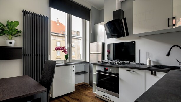 Una cucina moderna con forno a incasso, piano cottura a gas e un'ampia finestra che si affaccia sulla città.
