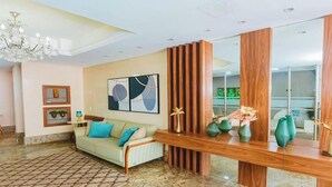 A modern living room with a sofa, a wooden console table, and a large mirror.