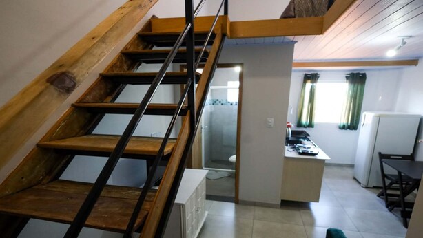 Una escalera conduce a un área de cocina con una mesa y sillas.