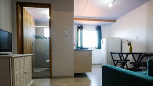 Un espacio habitable compacto con kitchenette, comedor y baño.