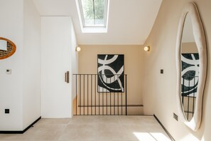 A modern interior with a staircase, a large abstract painting, and a skylight. - The Primrose Mews in Greater London (London)