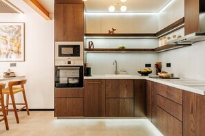 A modern kitchen with wooden cabinets, a built-in oven, a microwave, and a sink.