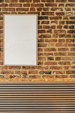 A framed artwork on a brick wall. - The Primrose Mews in Greater London (London)