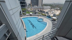 A rooftop swimming pool with a circular design and the word "JAMAC" on the water. - StayShort - Stylish DIFC Apartment Sleeps 4 with Pool & Gym (DIFC)