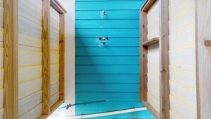 A narrow hallway with wooden walls and a blue door. - Puddin Place: 3 BR, 2.5 BA House in Crystal Beach, Sleeps 10 (Bolivar Peninsula)