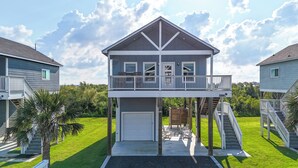Une maison à deux étages dotée d’un balcon, d’un garage et d’un escalier menant à l’étage supérieur.