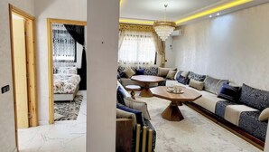 A modern living room with a sofa set, a coffee table, and a chandelier.