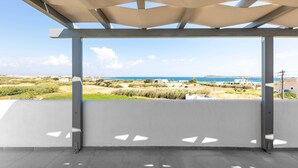 An open balcony with a view of the sea and distant buildings. - Paros Beach Studio Casa Costa Oro, 300m from Golden Beach (1BR 1BA) (Paros)