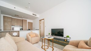 A modern living room with a sofa, a coffee table, and a TV. - Cozy 1 Bedroom In High Floor In Dubai Marina (Dubai)