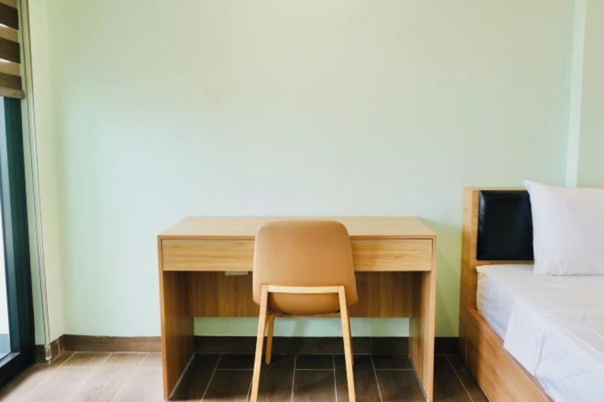 A room with a bed, a desk, and a chair.