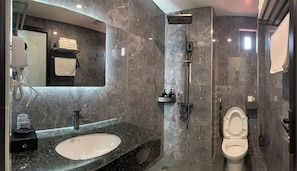 A modern bathroom with a marble sink, a shower, and a toilet. - Jademay Airport Hotel (Hanoi)