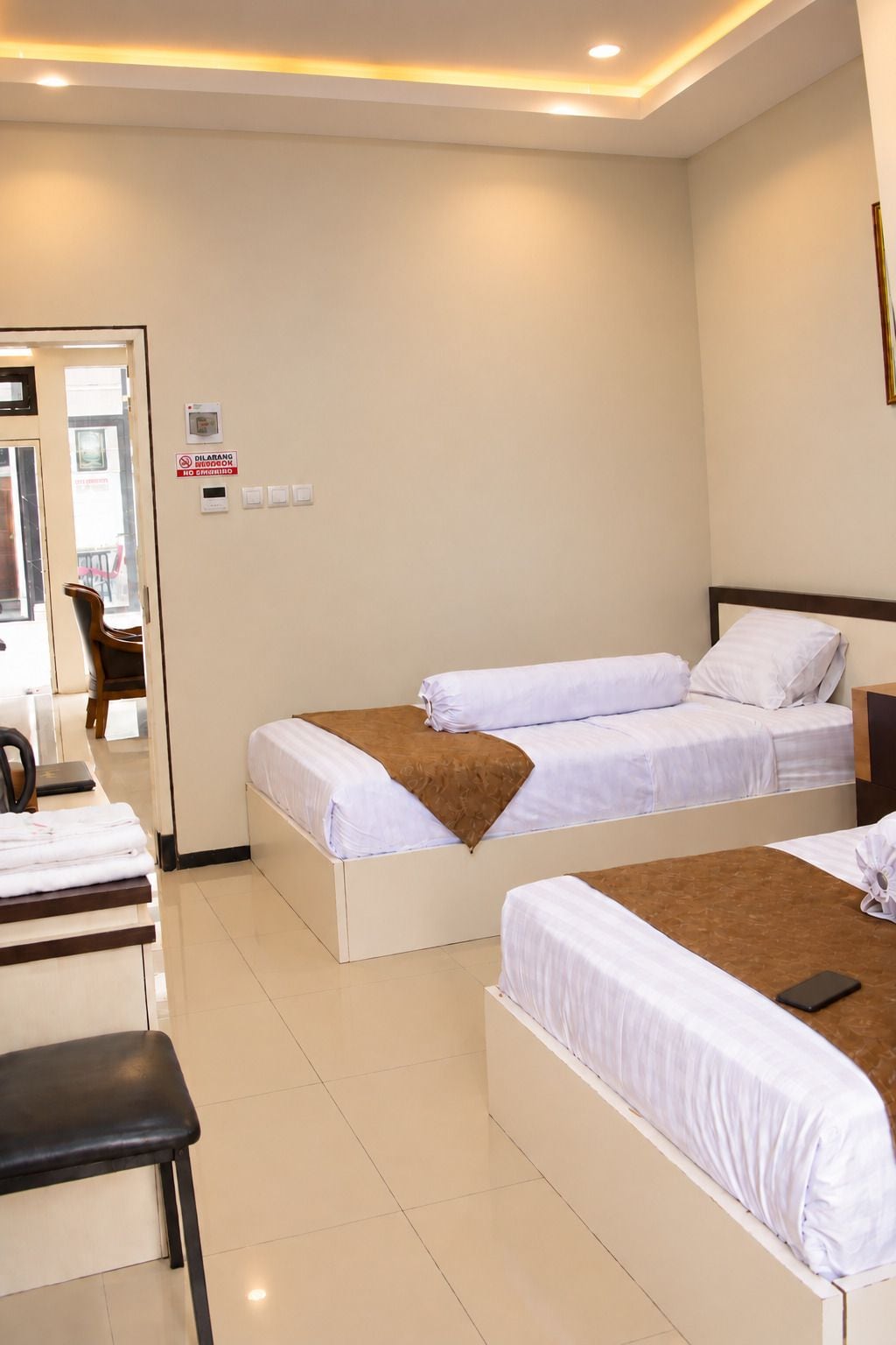 A hotel room with two beds, a desk, and a chair.