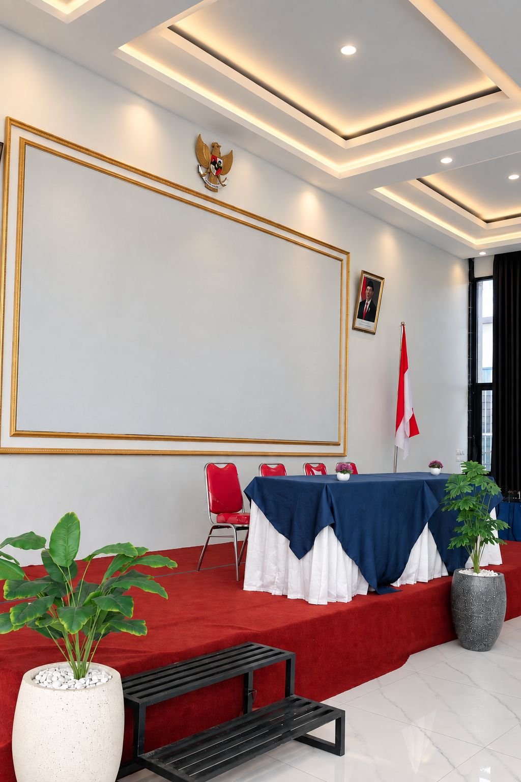 A conference room with a large whiteboard, red and white chairs, a table with a blue tablecloth, and a flag.