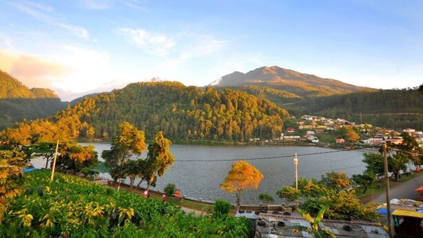 A scenic view of a lake surrounded by hills and a small village. - Grand Wijaya Hotel dan Villa Sarangan (Plaosan)