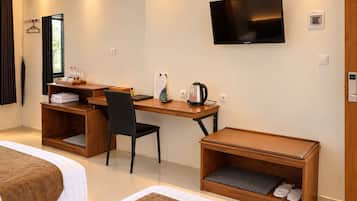 Una habitación de hotel con una cama, un escritorio con una silla, un televisor y un zapatero.
