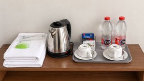 A hotel room's breakfast tray with a kettle, two cups, a box of Sari Wangi tea, and two bottles of Cielo water. - Grand Wijaya Hotel dan Villa Sarangan (Plaosan)