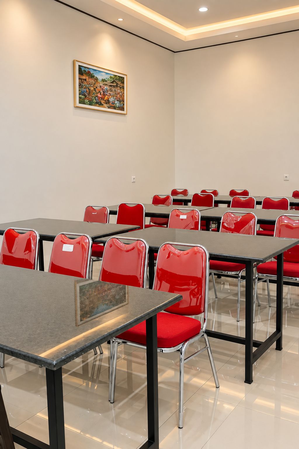 A conference room with tables and chairs, a painting on the wall, and a tiled floor.