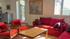 A living room with red furniture, a wooden coffee table, and a map on the wall. - Le Grand mazet (ARLES)