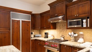 A kitchen with wooden cabinets, a stainless steel stove, a microwave, and granite countertops. - Trail's End Lodge at Deer Valley Resort - Two Bedroom Residence with Spa #402 2 Condo (Park City)