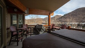 A covered outdoor seating area with Adirondack chairs and a pool table, overlooking a mountainous landscape. - Trail's End Lodge at Deer Valley Resort - Three Bedroom Residence with Spa #506 3 Condo (Park City)