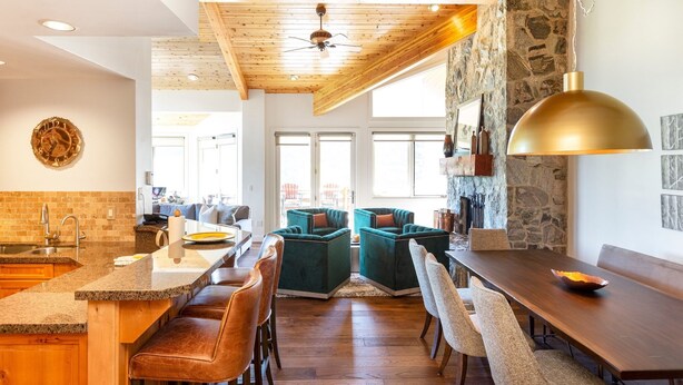 A modern kitchen with a stone accent wall, wooden ceiling, and a large island with bar seating. - Trail's End Lodge at Deer Valley Resort - Three Bedroom Residence with Spa #506 3 Condo (Park City)