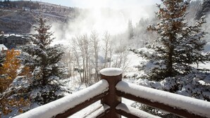 A snowy landscape with a wooden fence in the foreground.