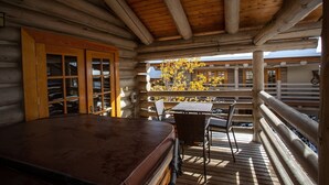 A log cabin with a wooden deck, a hot tub, and a dining area with outdoor seating. - Pine Inn at Trail's End Lodge - Two Bedroom Condo Residence with Spa #8 by Deer Valley Resort (Park City)