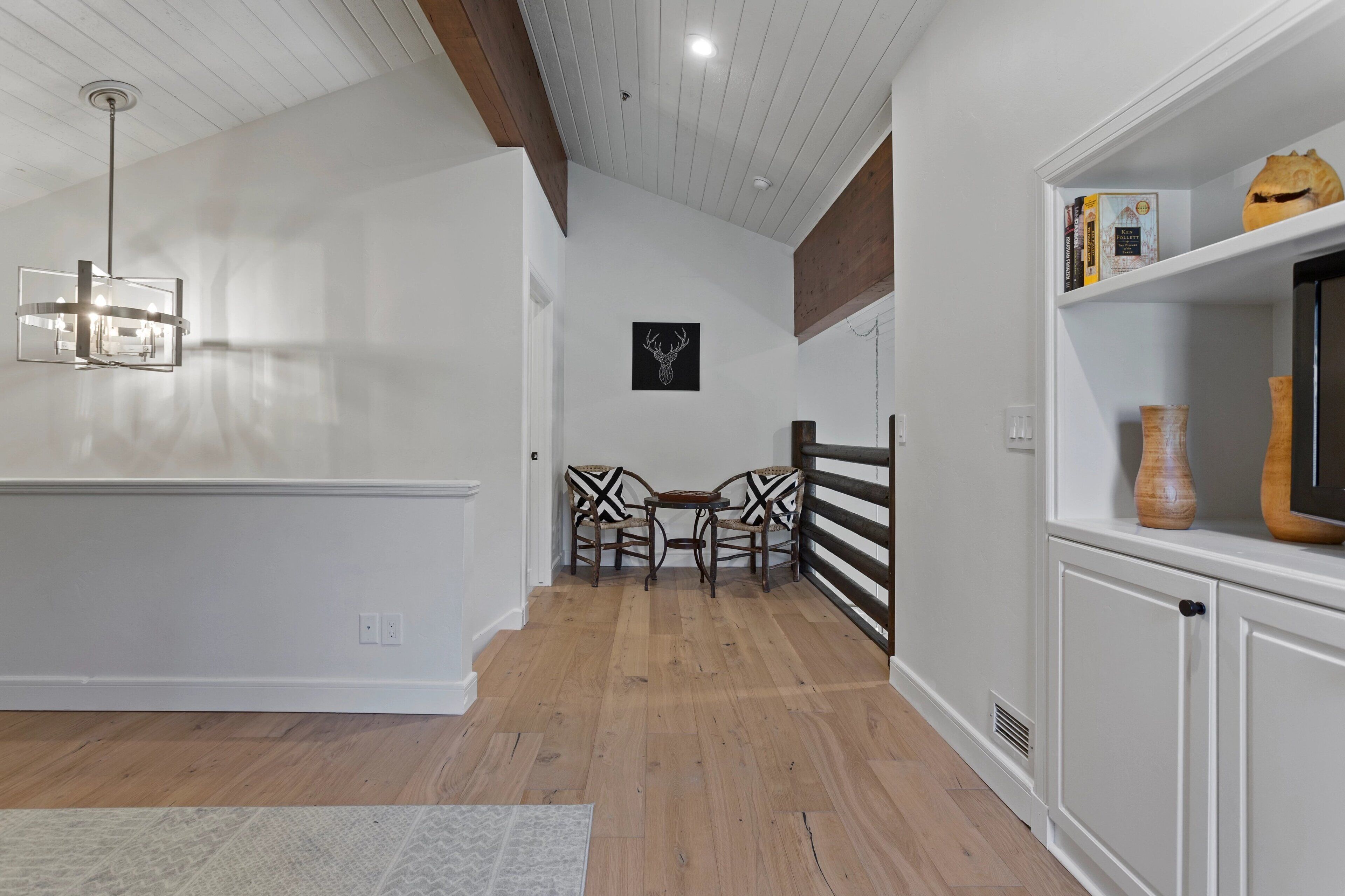 A modern kitchen with a wooden ceiling, white walls, and a built-in cabinet.