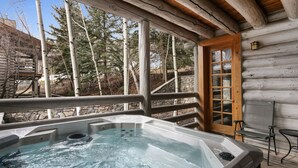 A hot tub on a wooden deck with a stone wall and birch trees in the background. - Pine Inn 9 - Two Bedroom Condo with Spa Trail's End Lodge by Deer Valley Resort (Park City)
