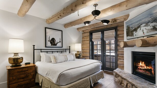 A bedroom with a bed, a nightstand, a lamp, a fireplace, and a framed picture on the wall. - Pine Inn 9 - Two Bedroom Condo with Spa Trail's End Lodge by Deer Valley Resort (Park City)