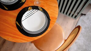 A dining table with black and white plates, a wine glass, and a fork. - DAWN 145 (Vila Olímpia São Paulo)
