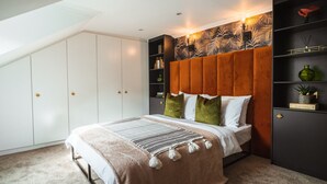 Ein Schlafzimmer mit einem Bett, einem großen Kleiderschrank, einer Kopfteil und einem Regal mit Dekoration.