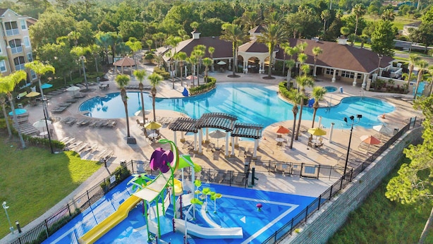 Un complexe hôtelier doté de plusieurs piscines, d’un parc aquatique et d’espaces de détente entourés de palmiers.