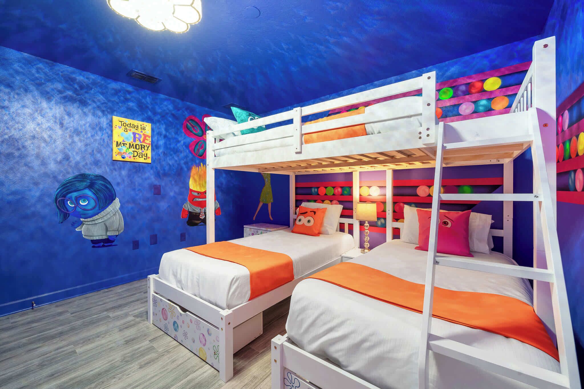 Una habitación infantil con literas, un mural y un cartel sobre un día de recuerdos.