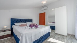 A bedroom with a bed, a nightstand, a dresser, and a door. - Villa Sami Zadar Villas (Benkovac)