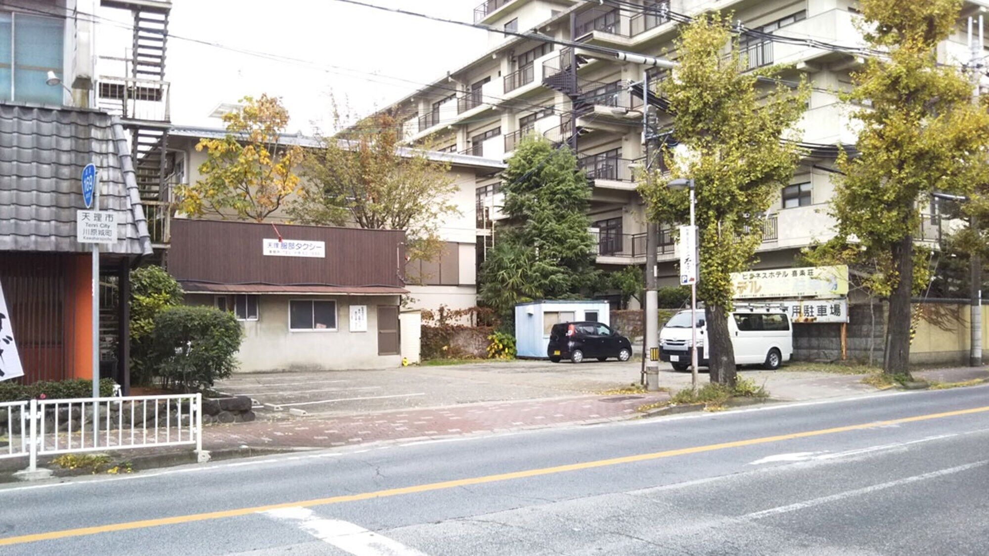 Un edificio residenziale a più piani con un'area di parcheggio antistante.