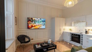 A modern kitchen with white cabinets, a black oven, and a marble backsplash. - The Devonshire Suite - Your 5 Star West End Stay! (Glasgow)