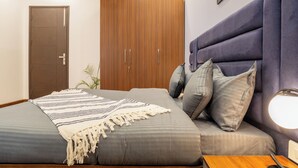 Un dormitorio con cama, armario, mesita de noche y lámpara.