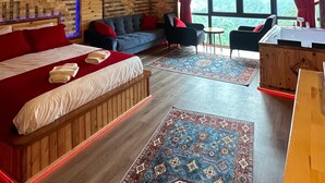 Een gezellig houten chalet met een groot bed, een bank en een eethoek.