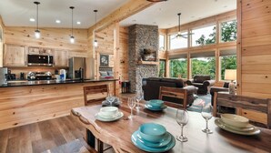 A wooden interior with a kitchen, dining area, and seating space. - 2BR Cabin with Private Indoor Pool and Hot Tub (Cosby)