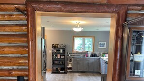 A wooden interior with a kitchen area, a dining space, and a living room.