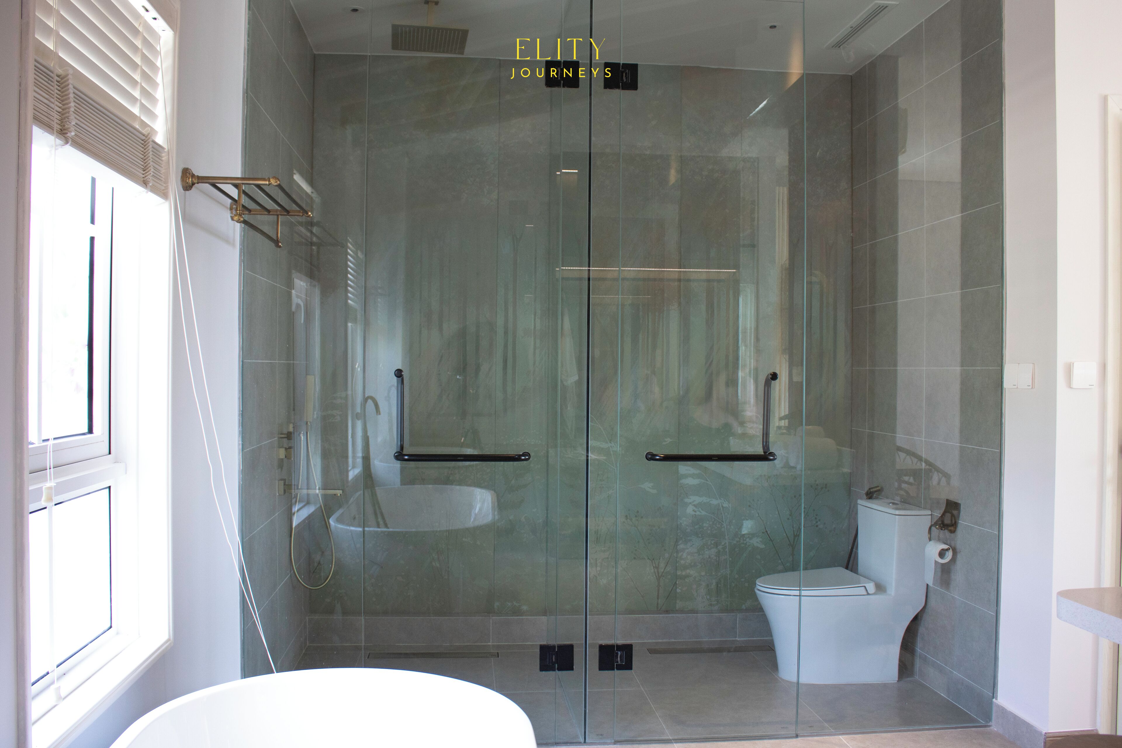 Un baño moderno con ducha envuelta en vidrio, inodoro blanco y bañera.