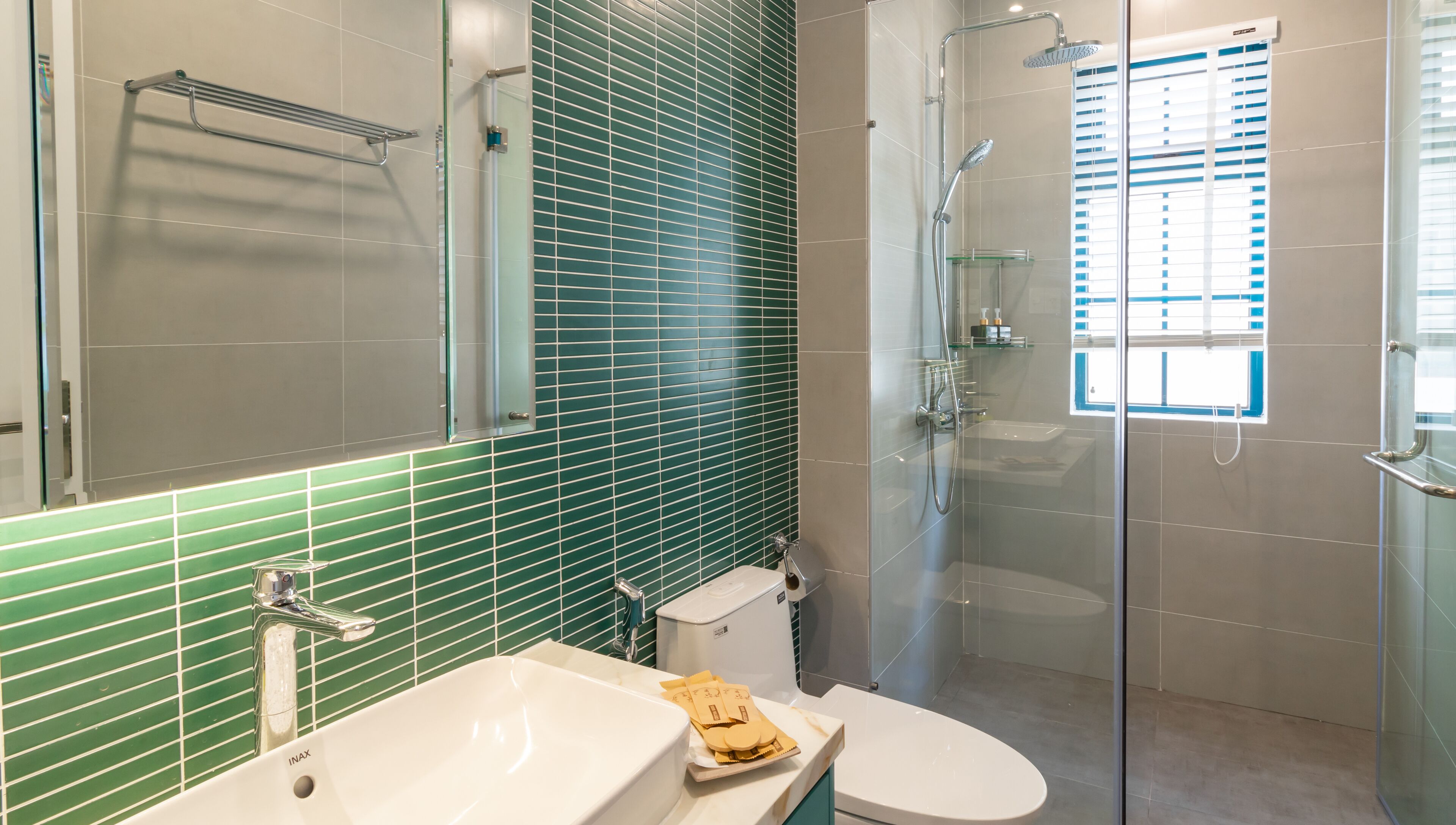 A modern bathroom with a glass shower enclosure, a white sink, and a toilet.